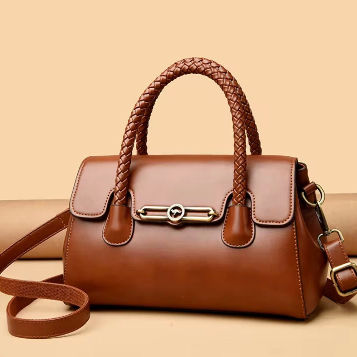 Brown leather handbag with braided handle on a beige background